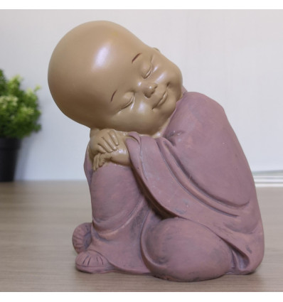 Piccolo Buddha-pensatore. Figurina monaco buddista bambino a buon mercato.